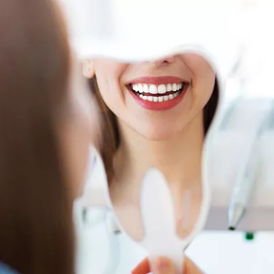 Woman looking at her smile in a mirror